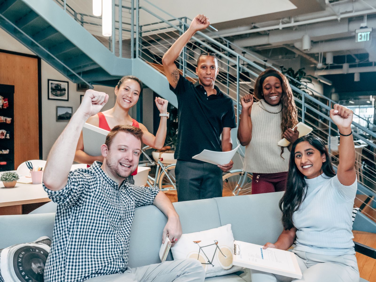 Coworkers celebrating in an office; a credit union travel club or workplace perk can include cruises