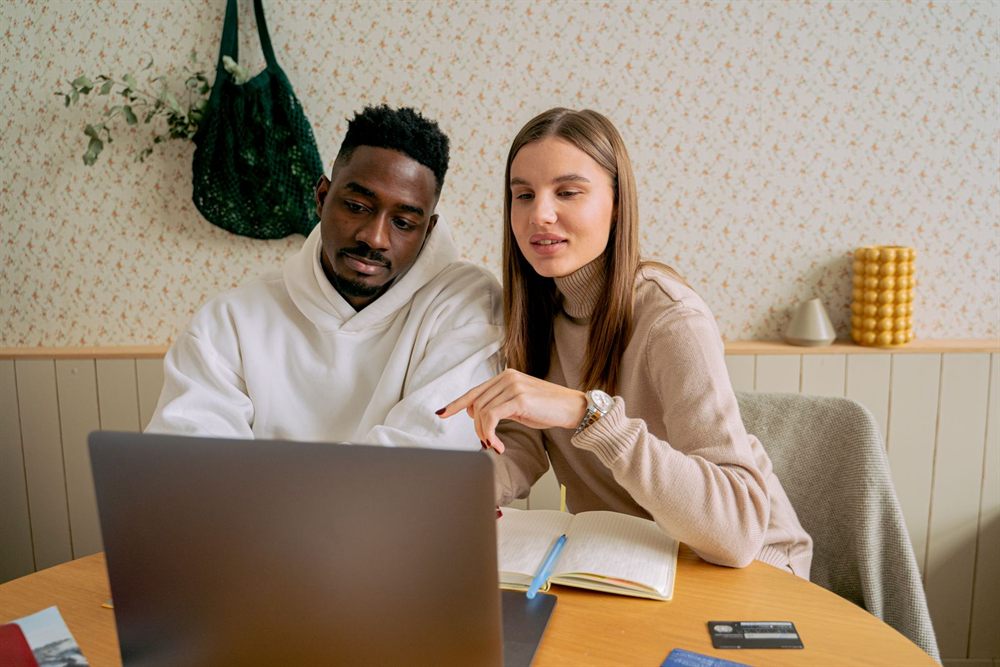 Couple comparing member cruise offers on a laptop at home